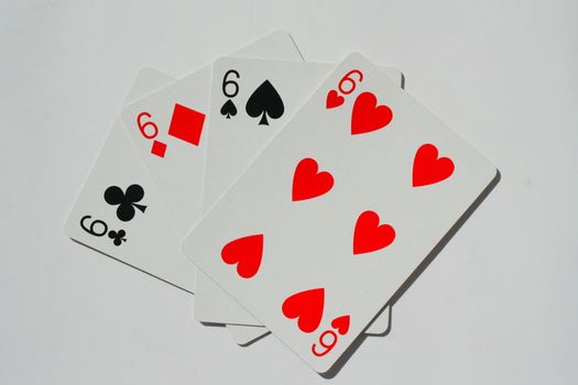 Close up of four sixes on a white background.
