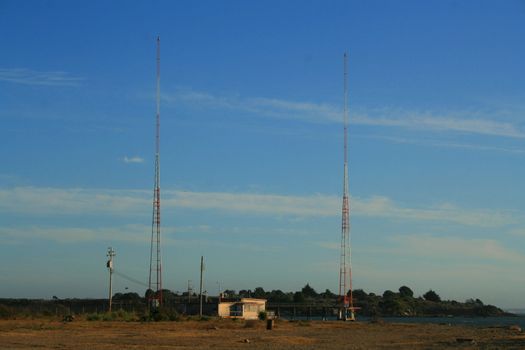 Tall radio towers over blue sky.

