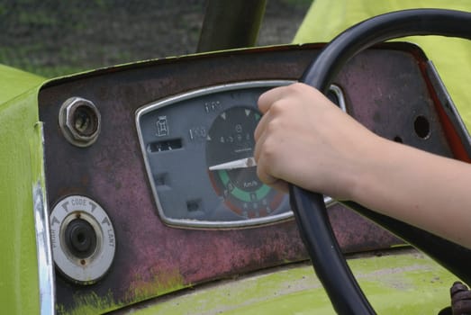 Boy holding a tractor wheel.