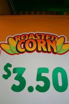 Close up of a roasted corn price sign.