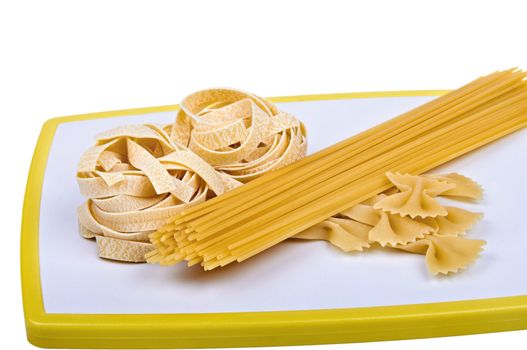Collection of different italian pasta on chopping board isolated on a white background. The file includes a clipping path.
