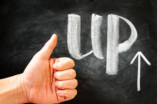 Thumb Up with an arrow written on blackboard