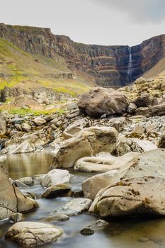 Hengifoss is the second highest waterfall on Iceland. The most special thing about the waterfall are multicolored layers in the basalt rock behind waterfall. Vertical view.