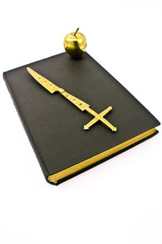 Golden cross and apple on old book 