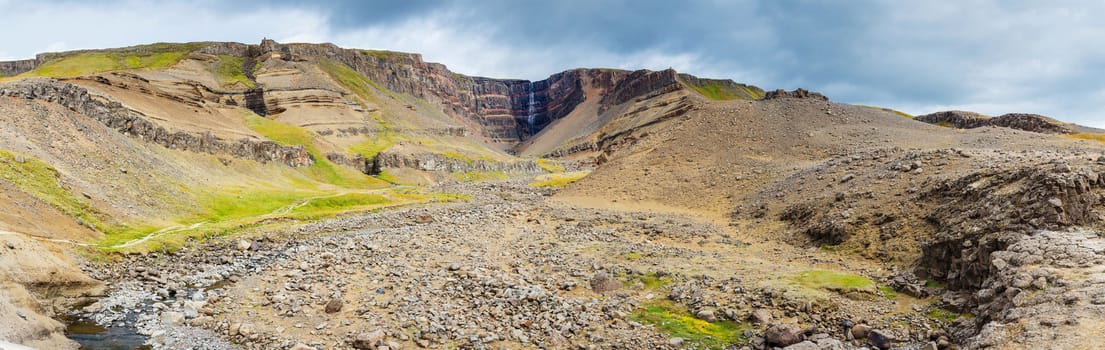 Panorama of Hengifoss is the second highest waterfall on Iceland. The most special thing about the waterfall are multicolored layers in the basalt rock behind waterfall