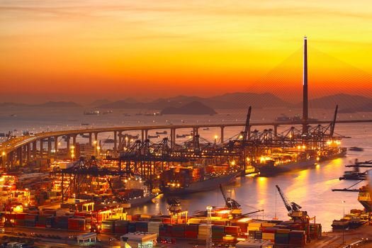 Port warehouse with cargoes and containers at sunset