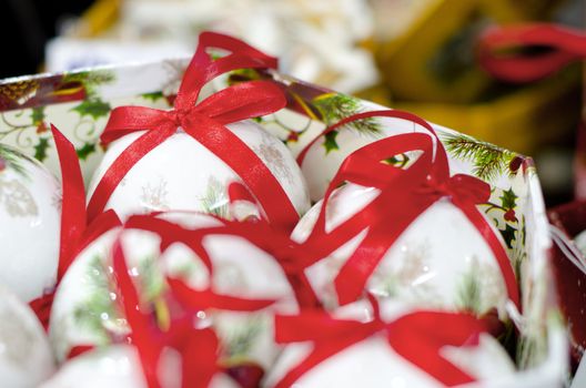 white collection of Christmas Balls with red ribons