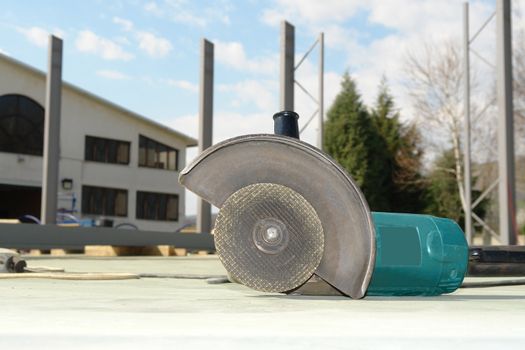 Close-up circular abrasive cutoff saw grinding machine on the workplace floor