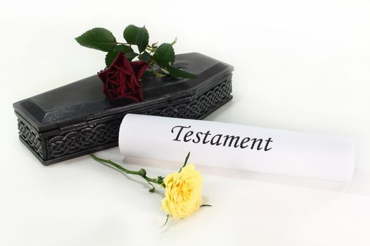 a small coffin with roses and Testament