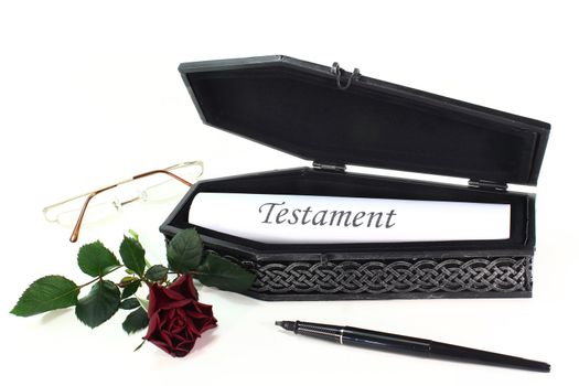 a small coffin with roses and Testament