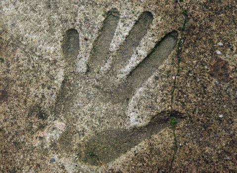 Human handprint in old weathered concrete floor