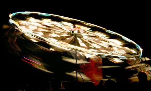 rotating fair ride at night with long exposure