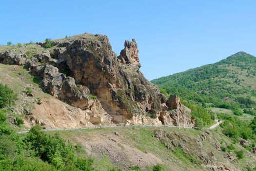 landscape with rocks hill and clear blue sky over the road