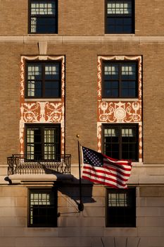 Detail of a building with windows and an American flag