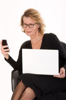 senior secretary with laptop sends a text message via your mobile phone