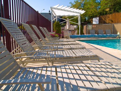 Lounge chairs by the pool on a sunny day