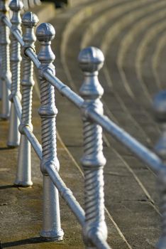 Ornate silver painted metal railings on Blackpool promenade above the steps leading down to the beach