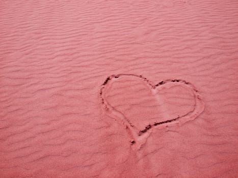 Red Heart in the Sand on a Sunny Day