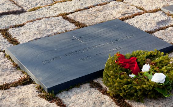 Xmas wreath and white rose lay by the side of the everlasting flame at President Kennedy memorial in Arlington Cemetery