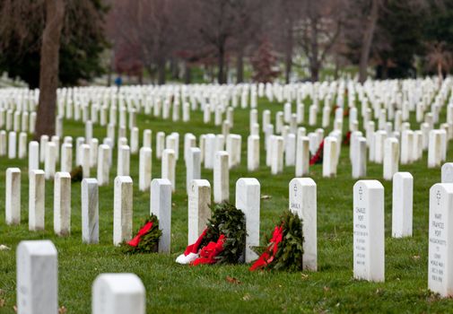 ARLINGTON, VA - DECEMBER 18: Christmas wreaths on gravestones in Arlington National Cemetery on December 18, 2011. The wreathes have been donated each year since 1992.