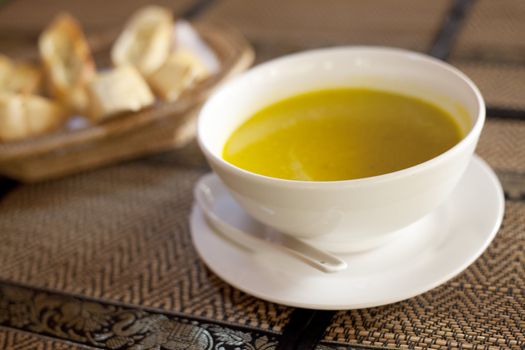 Bowl of pumpkin soup in a restaurant with bread