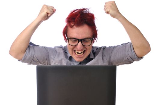 Young man angry with computer raises both fists and yells