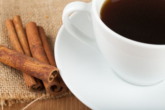 Cup of coffee and cinnamon on a wooden table