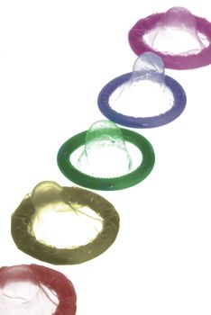 a selection of different coloured condoms on a white background