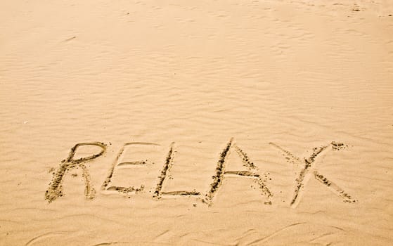 Relax Written in the Sand on a Sunny Day