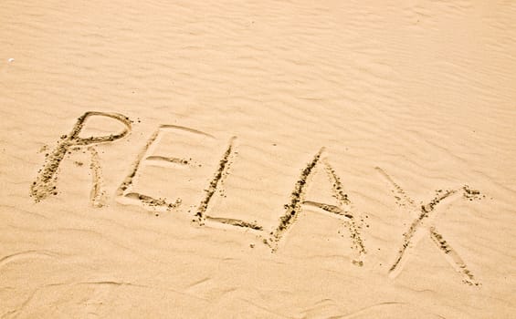 Relax Written in the Sand on a Sunny Day