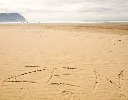 Zen Written in the Sand on a Sunny Day with Footprints