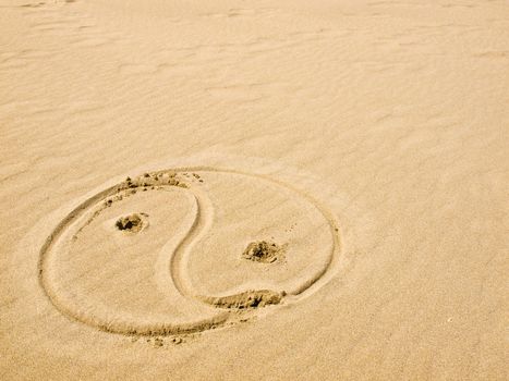 Yin and Yang Symbol Written in the Sand on a Sunny Day