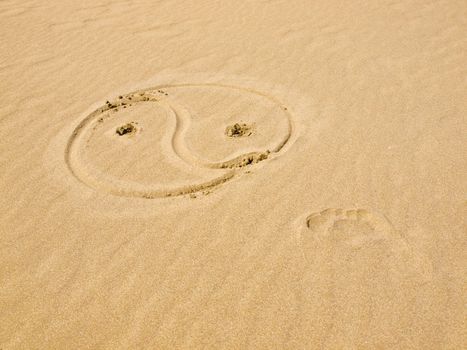 Yin and Yang Symbol Written in the Sand on a Sunny Day