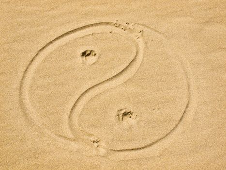 Yin and Yang Symbol Written in the Sand on a Sunny Day