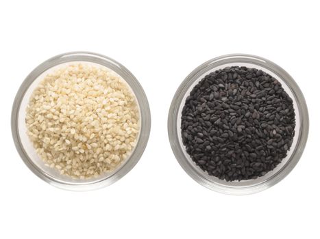 close up of bowls of  white and black sesame seeds