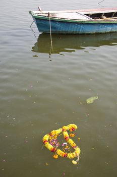 ritual flowers and boat in sacred Ganges river, Varanasi,India