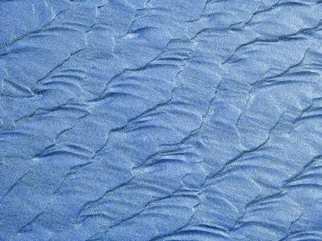 Abstract background of blue sand ripples at the beach 