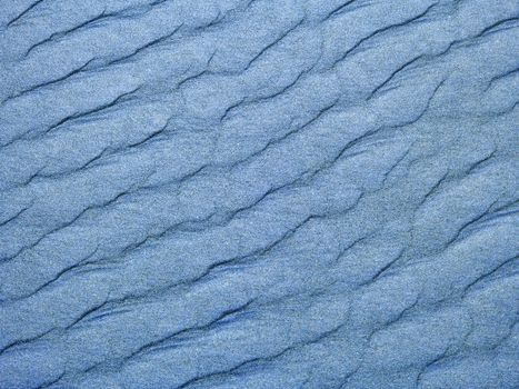 Abstract background of blue sand ripples at the beach 