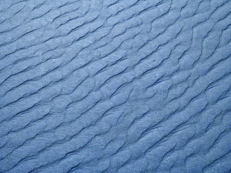 Abstract background of blue sand ripples at the beach 