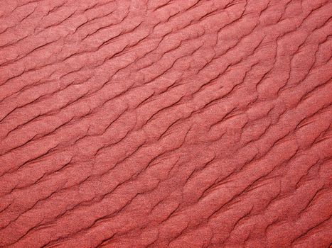 Abstract background of red sand ripples at the beach 