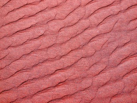 Abstract background of red sand ripples at the beach 