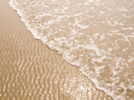 Foamy Ocean Shoreline at a Sunny Beach 