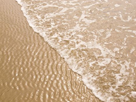 Foamy Ocean Shoreline at a Sunny Beach 