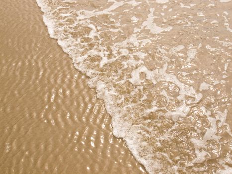 Foamy Ocean Shoreline at a Sunny Beach 