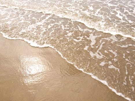 Foamy Ocean Shoreline at a Sunny Beach 