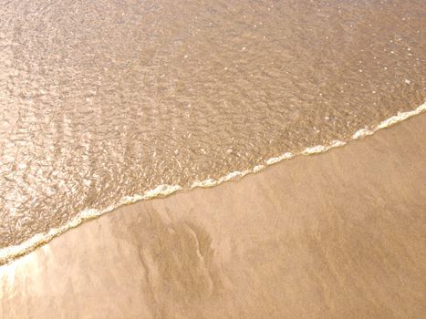 Foamy Ocean Shoreline at a Sunny Beach 