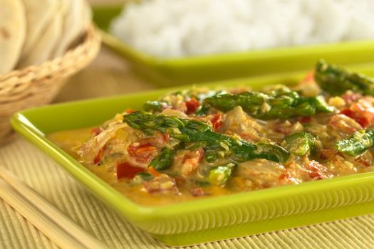 Green asparagus curry with chapati and rice in the back (Selective Focus, Focus on the asparagus head in the middle of the image)