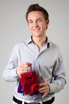 Portrait of a young man in formal attire with a New Year's gifts in their hands