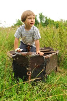 Cute little boy playing in an old deserted boat