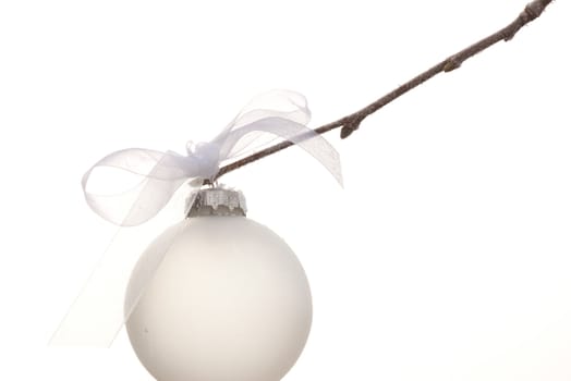 white christmas ornament hanging on a tree with a white background